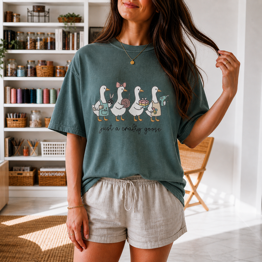 Model wearing the teal "just a crafty goose" T-shirt in a craft room