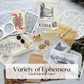 Assorted ephemera sample: a vintage camera ad, playing cards, buttons, a lace doily, stamps and puzzle pieces; contents vary by kit