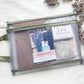 Junk journal kit packed in a green-trimmed zippered mesh pouch with journal, sampler pack and mini notebook