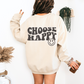 Back of a sand crewneck with "Choose Happy" in bold wavy black letters and a smiley face