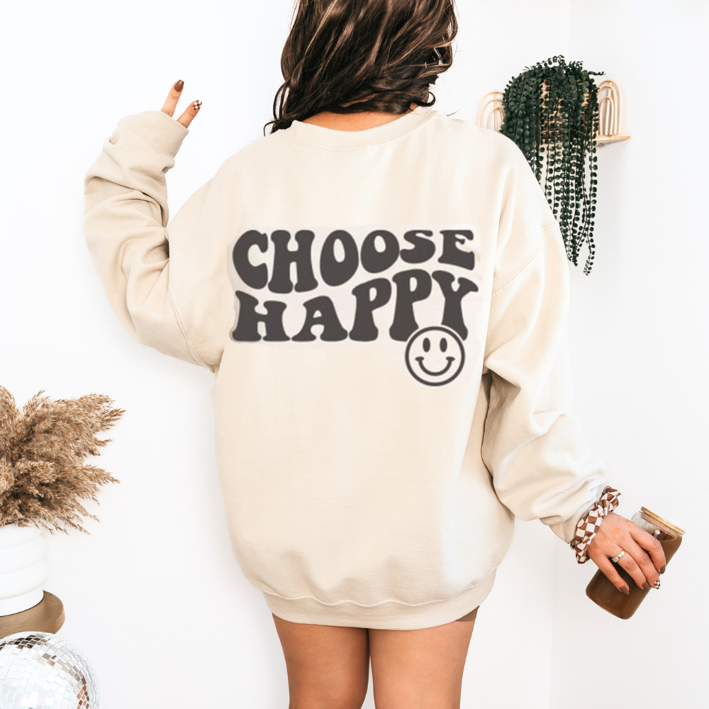 Back of a sand crewneck with "Choose Happy" in bold wavy black letters and a smiley face