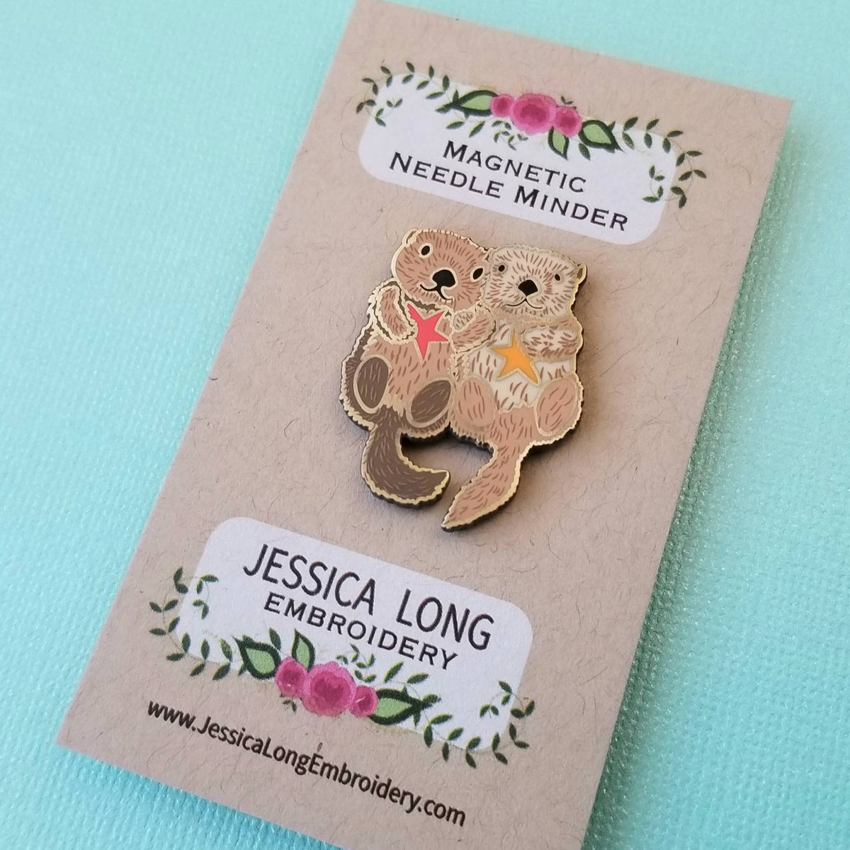 Sea otters magnetic needle minder by Jessica Long Embroidery on its backing card