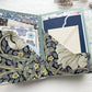 Open journal folio with dark floral pockets holding a patterned card, envelopes and lace-trimmed paper
