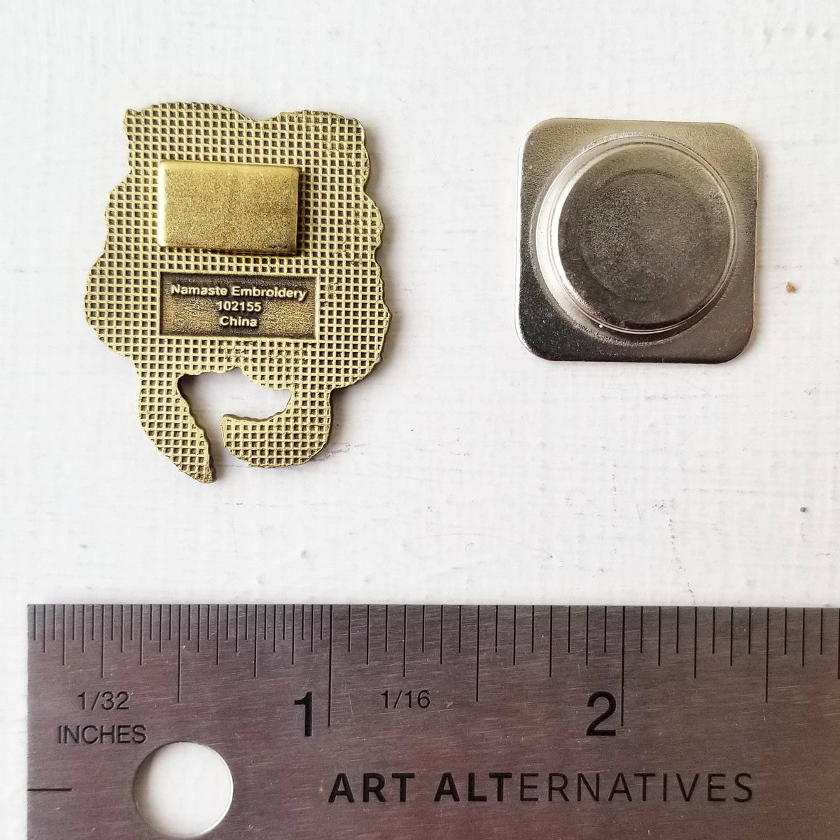 Back of the sea otters needle minder and its magnet, shown against a ruler for size