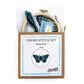 Kit contents in the box: hoop, white fabric, blue and green floss, needle and pattern
