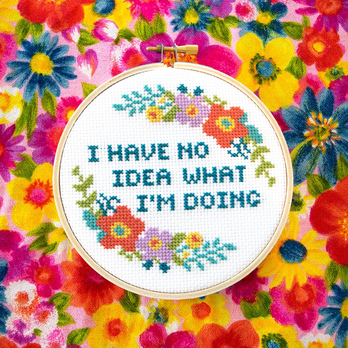 "I have no idea what I'm doing" cross stitch hoop on bright floral fabric