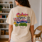 Model wearing a cream T-shirt with the Color your Calm print on the back, in a craft room