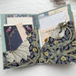 Open journal folio with navy floral pockets full of vintage papers, cards and a floral tag