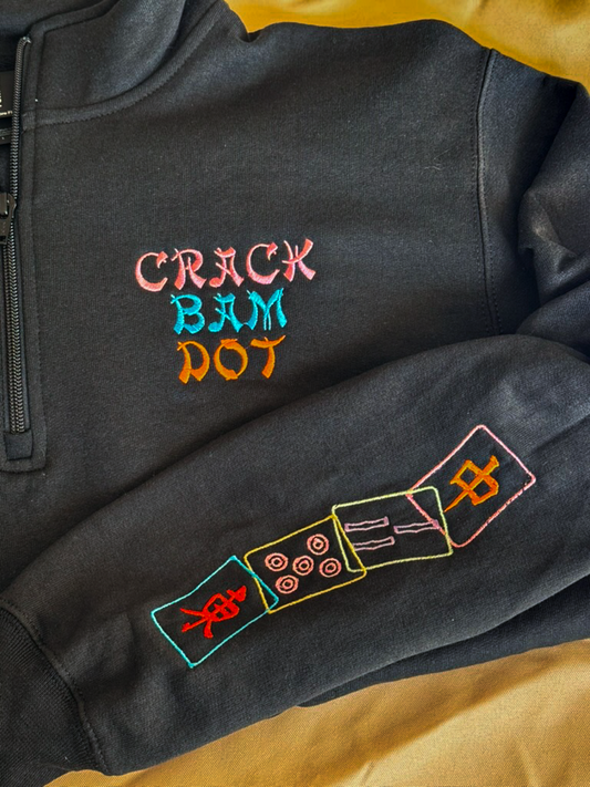 Black quarter zip embroidered CRACK BAM DOT with colorful mahjong tiles stitched down the sleeve