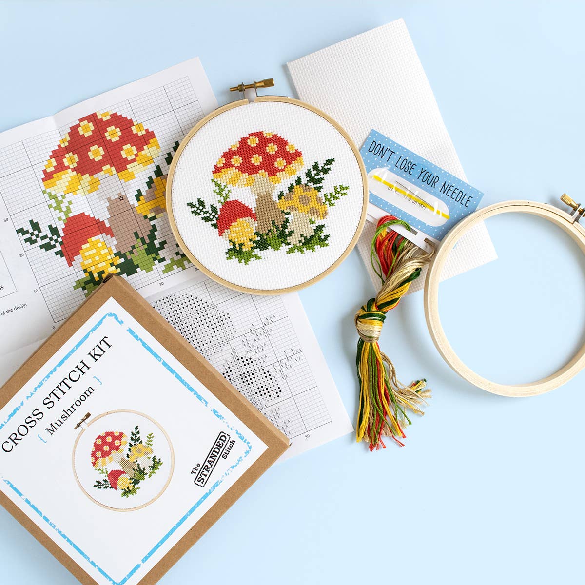 Mushroom cross stitch kit contents: pattern, fabric, hoop, floss and a needle card