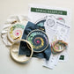 Spiral sampler embroidery kit: two stitched hoops, navy and cream fabric, floss and a beginner guide