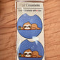 Pair of blue car coasters with a sleepy sloth next to a coffee cup