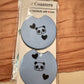 Pair of light blue car coasters with a small panda face and black hearts