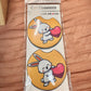 Pair of orange car coasters with a white bunny hugging a red heart