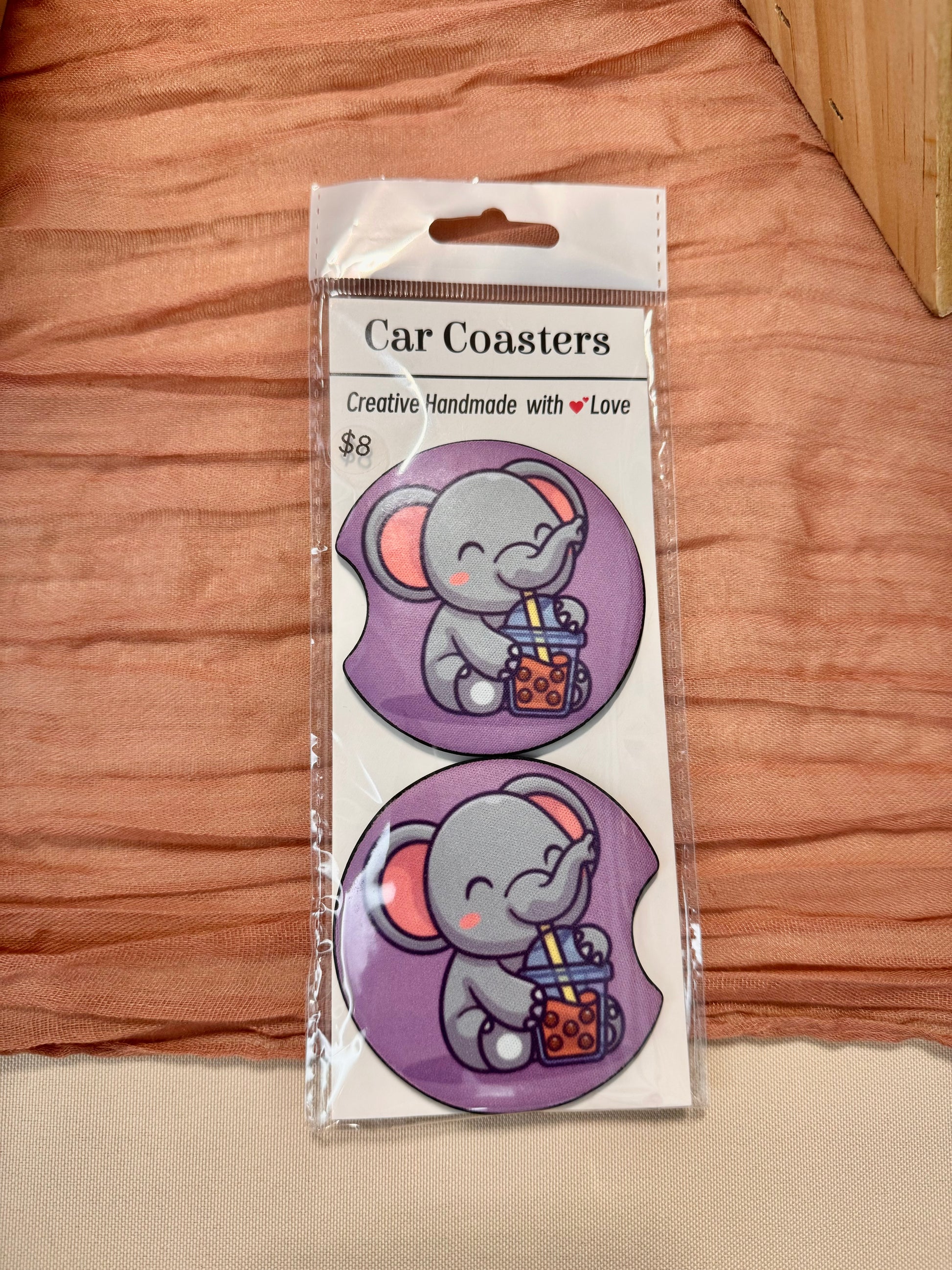 Pair of purple car coasters with a cartoon elephant sipping boba tea