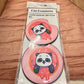 Pair of pink car coasters with a panda peeking out of a sprinkled donut