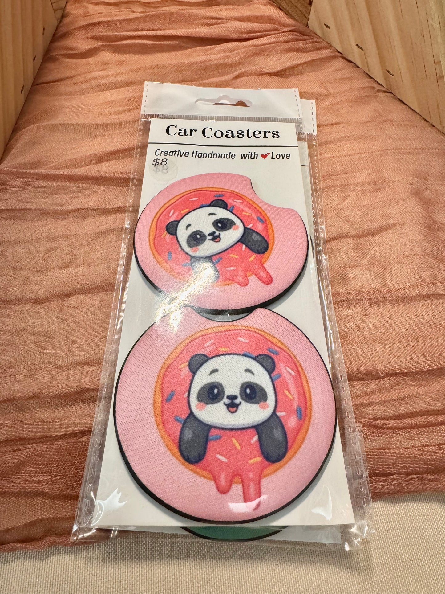 Pair of pink car coasters with a panda peeking out of a sprinkled donut