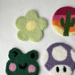 Punch needle coasters: green daisy, cactus sunset, green frog face and purple mushroom