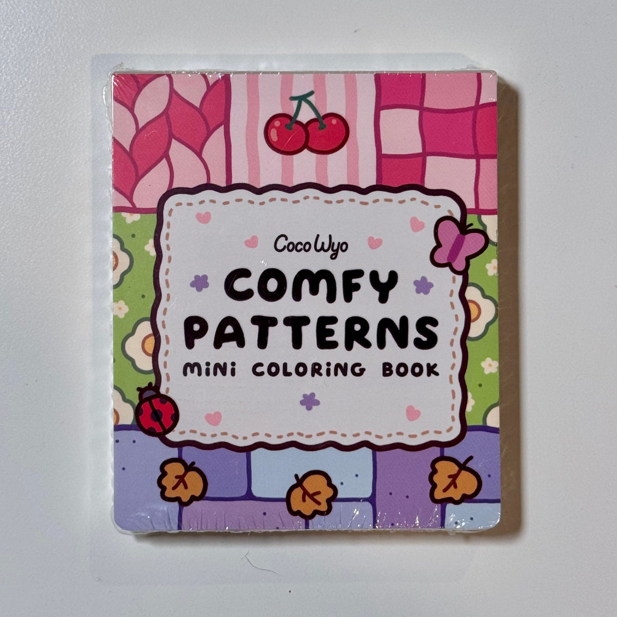 Comfy Patterns mini coloring book by Coco Wyo with a pink and purple patchwork cover