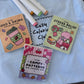 Coco Wyo Food & Drink, Stress Relief and Comfy Patterns mini coloring books on a Cozy Coloring Club tee