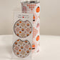 Fall Vibes car coasters with pumpkins, sweaters and plaid on pink, in packaging beside a matching tumbler