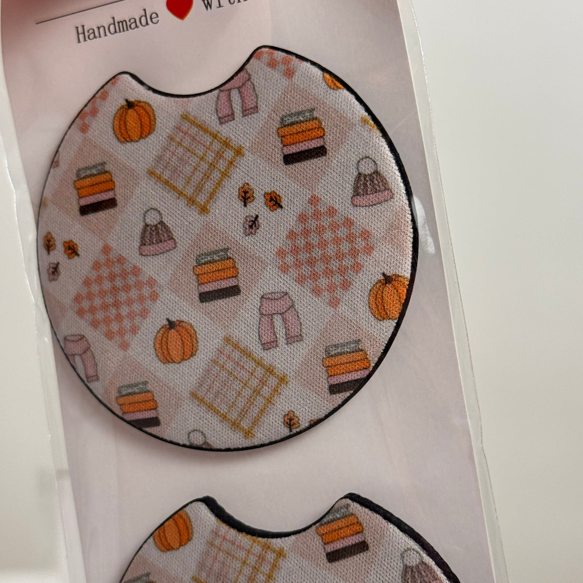 Close-up of the Fall Vibes car coaster pattern with pumpkins, knit hats, stacked sweaters and plaid