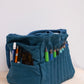 Side view of the bag with pens and tools in its outer pockets