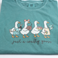 Close-up of the crafty geese print: geese holding scissors, yarn, a gift box and a glue gun