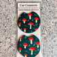 Pair of dark green car coasters with a red toadstool mushroom pattern