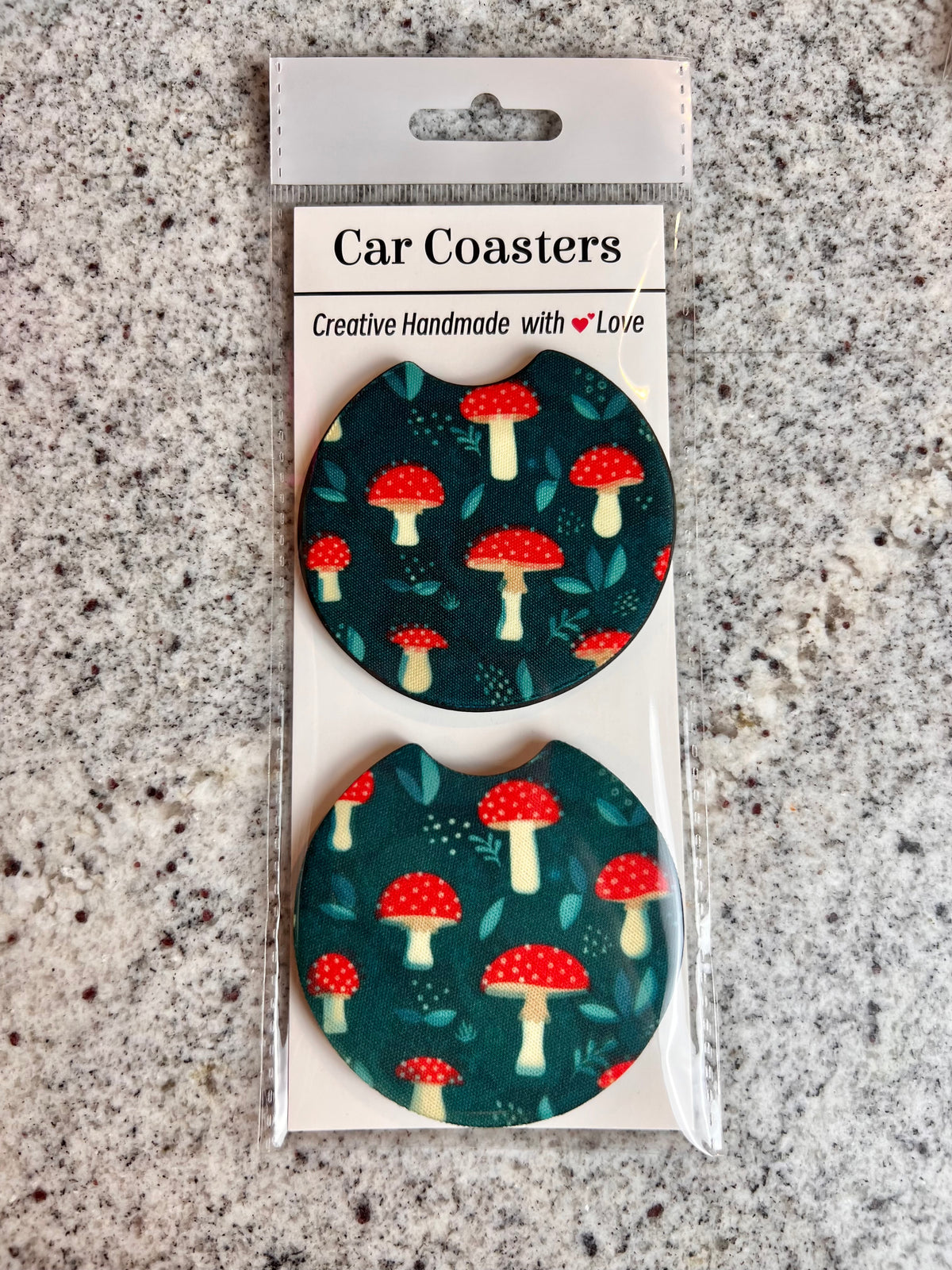 Pair of dark green car coasters with a red toadstool mushroom pattern