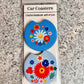 Pair of blue car coasters with a white daisy and red and blue folk flowers