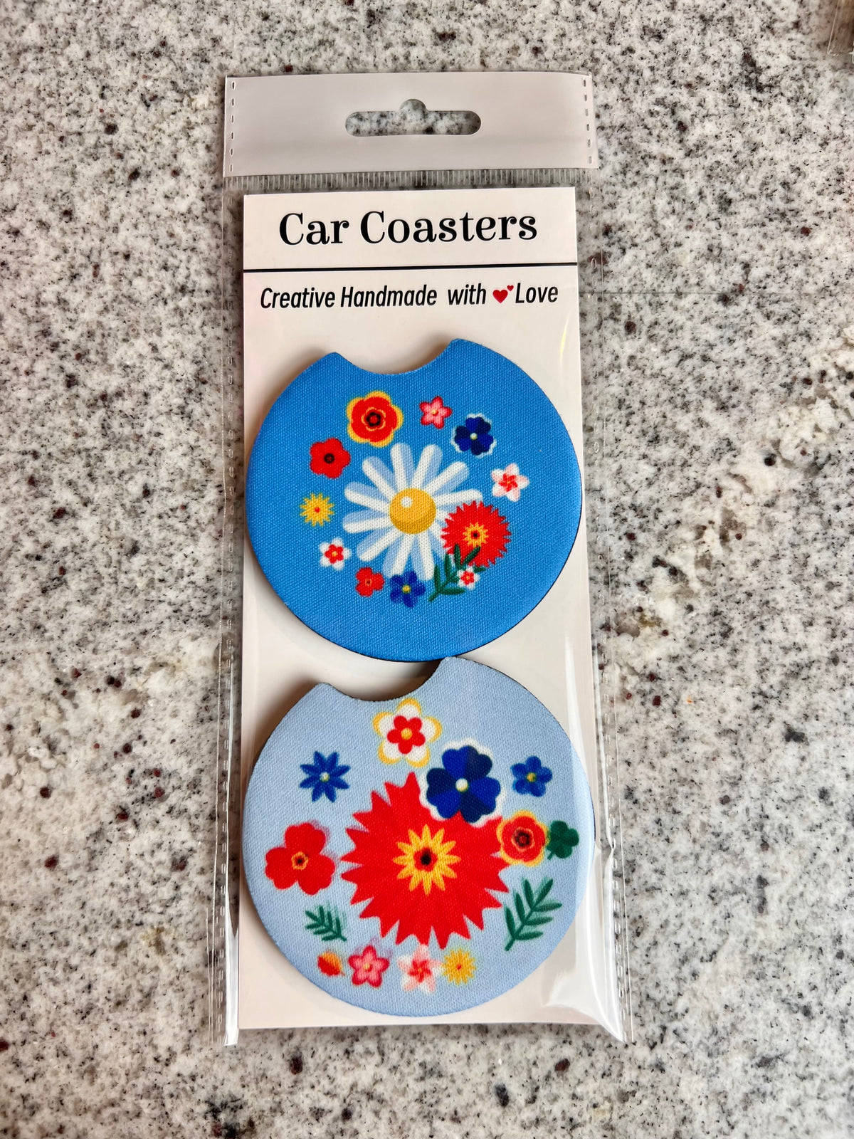 Pair of blue car coasters with a white daisy and red and blue folk flowers