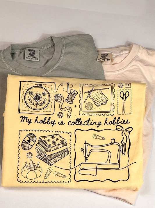 Butter yellow Hobby Collector tee printed "My hobby is collecting hobbies" with embroidery, knitting and sewing icons, on sage and peach tees