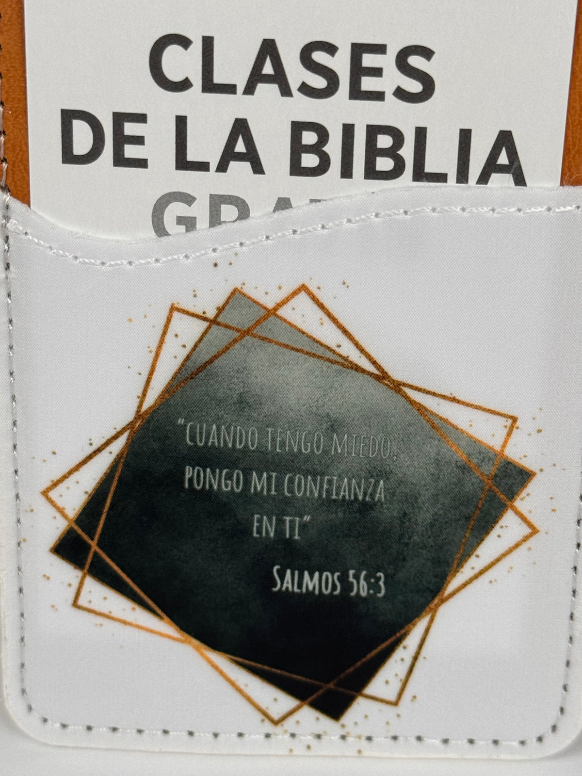 Close-up of a phone card wallet with a dark watercolor square, gold frames and the Salmos 56:3 quote