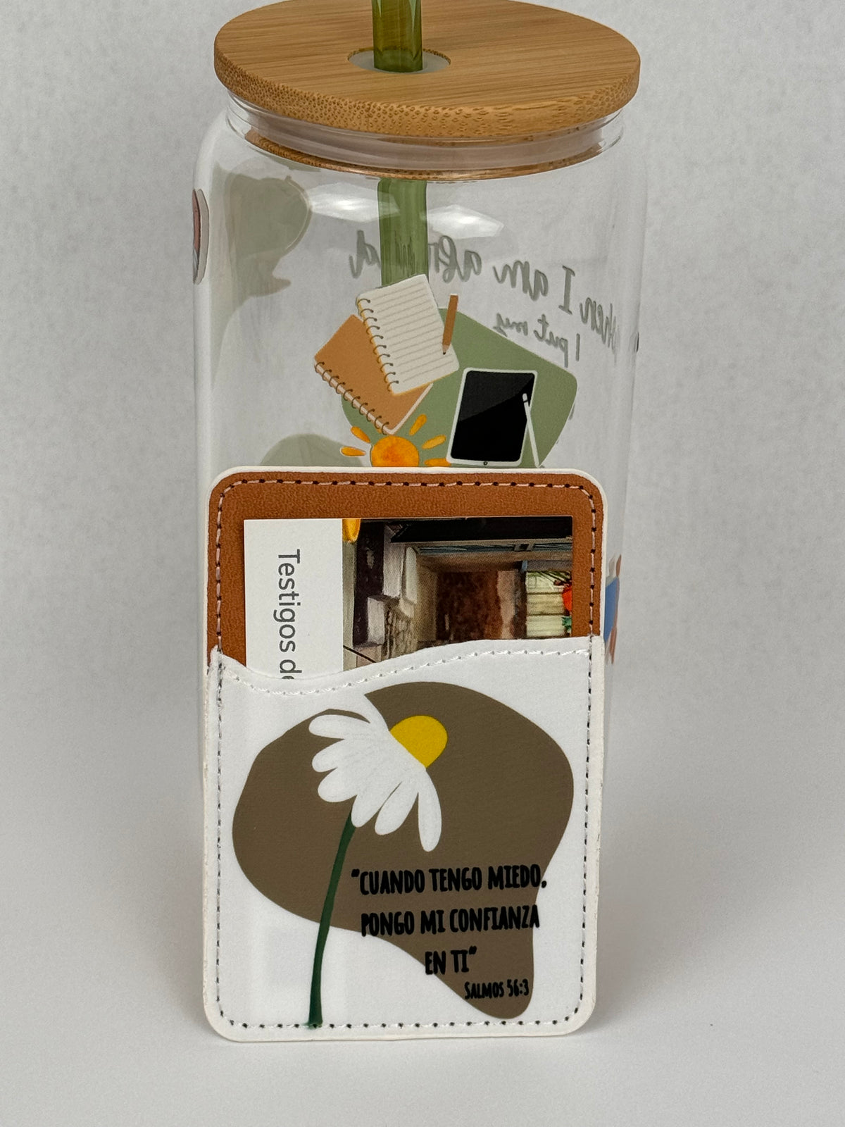 Phone card wallet with a white daisy on a taupe shape and the Salmos 56:3 quote, attached to a glass cup