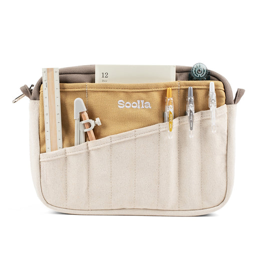 Soolla stationery pouch in cream and mustard with a ruler, pens and notepad in its slanted pockets