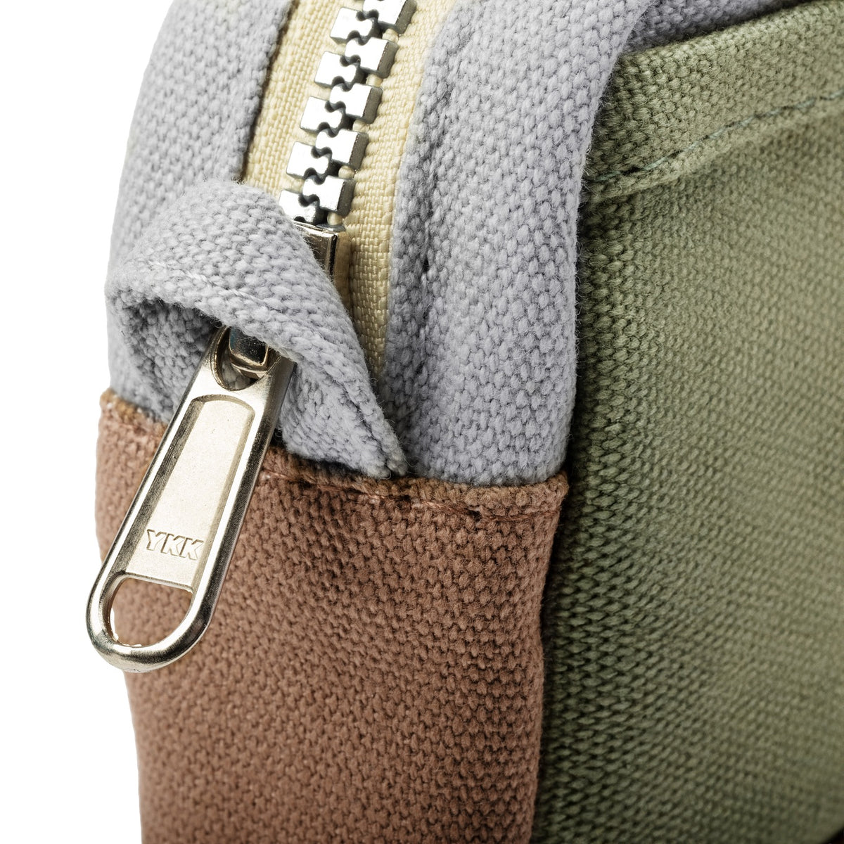 Close-up of the YKK zipper pull on the gray, brown and green Soolla pouch