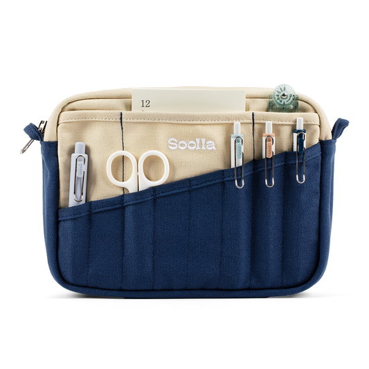 Navy and cream Soolla stationery pouch holding scissors, pens and a notepad
