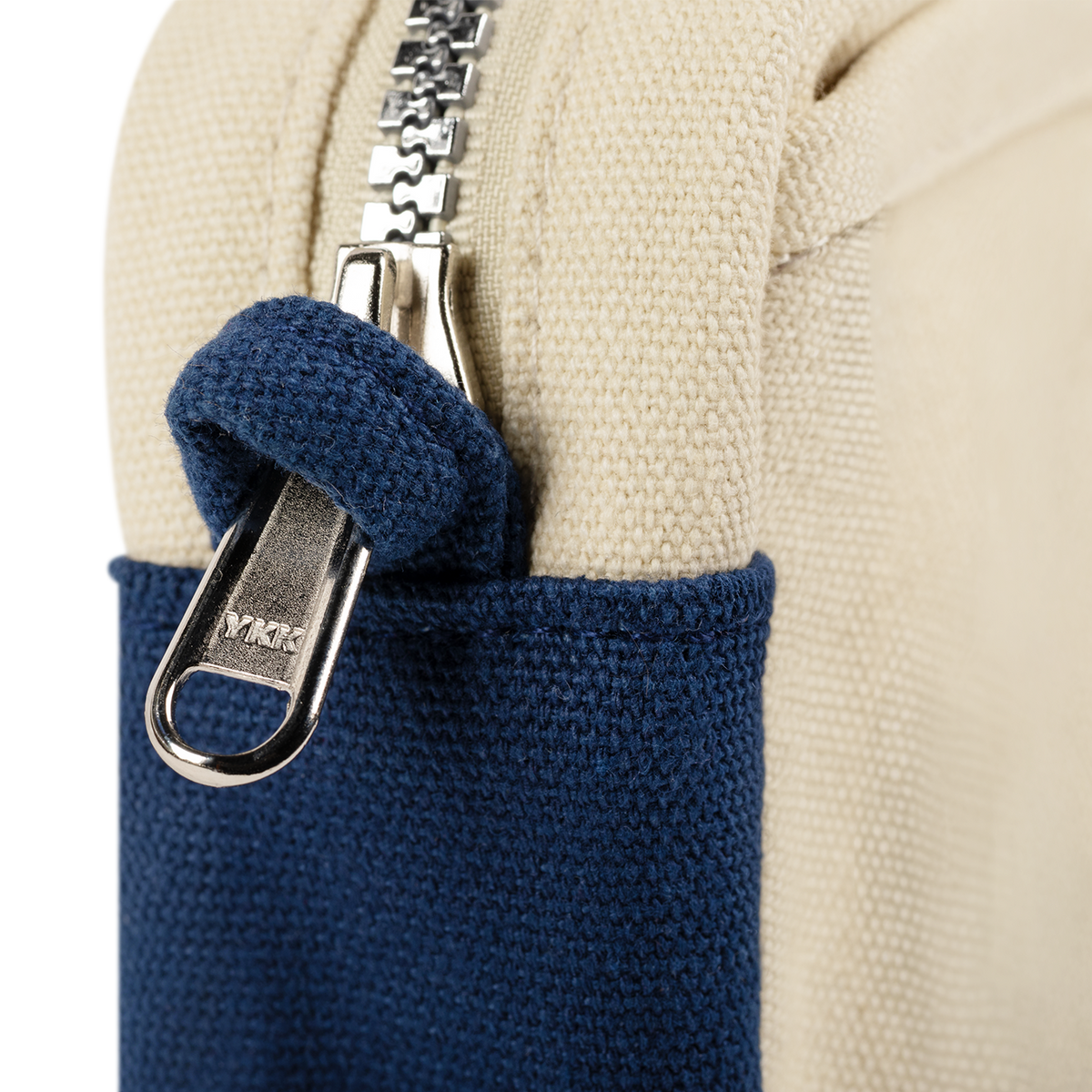 Close-up of the YKK zipper pull on the navy and cream Soolla pouch