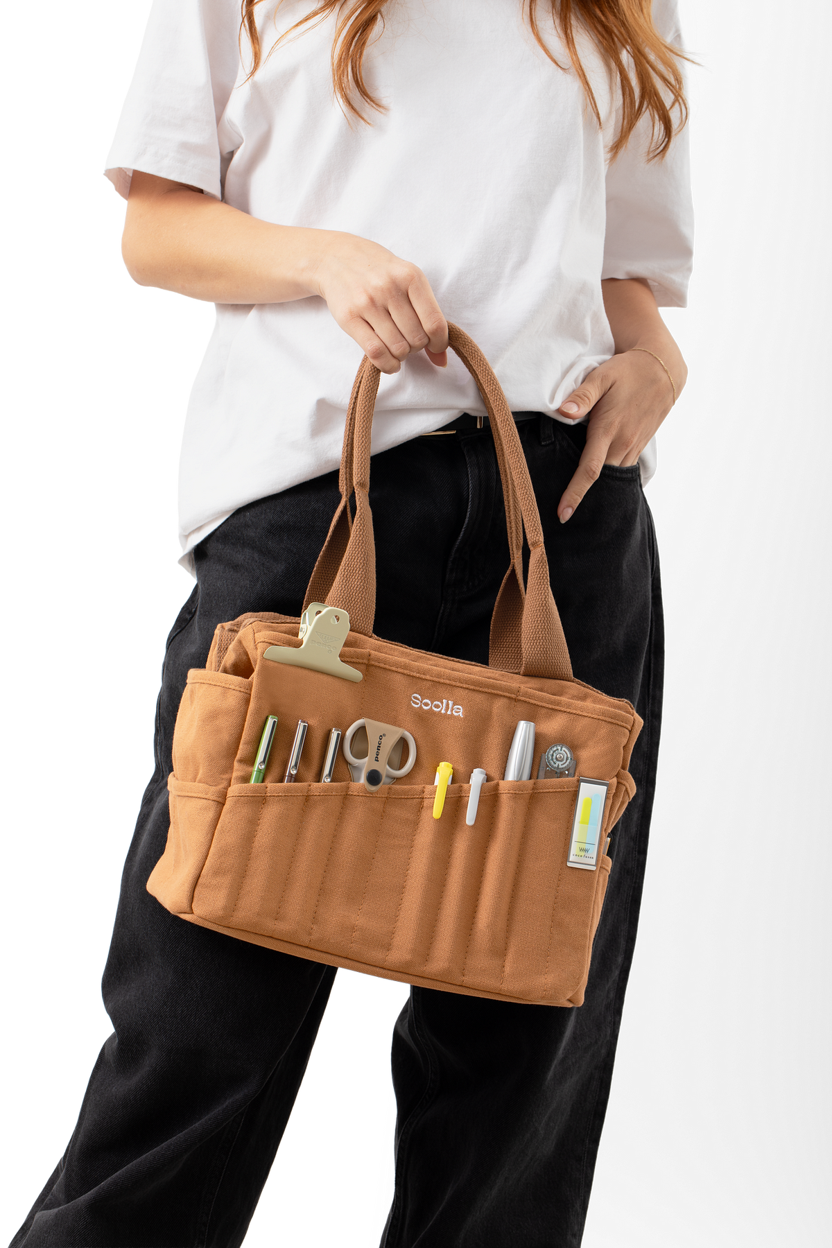 Model carrying the cinnamon Soolla craft bag with pens, scissors and tools in the front pockets
