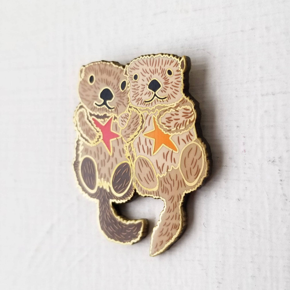 Angled view of the sea otter couple enamel needle minder
