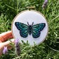 Hand holding the finished butterfly hoop among lavender plants